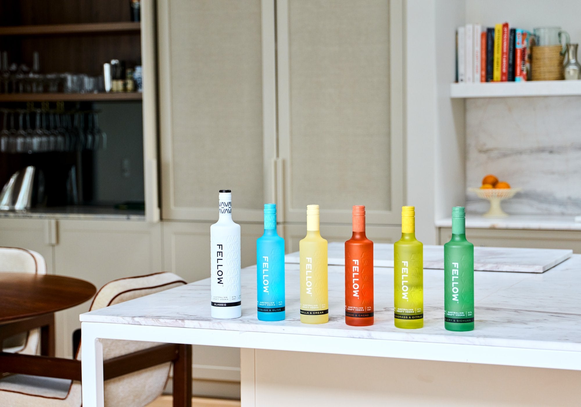 Set of colorful 'Fellow' Vodka bottles on a kitchen counter.